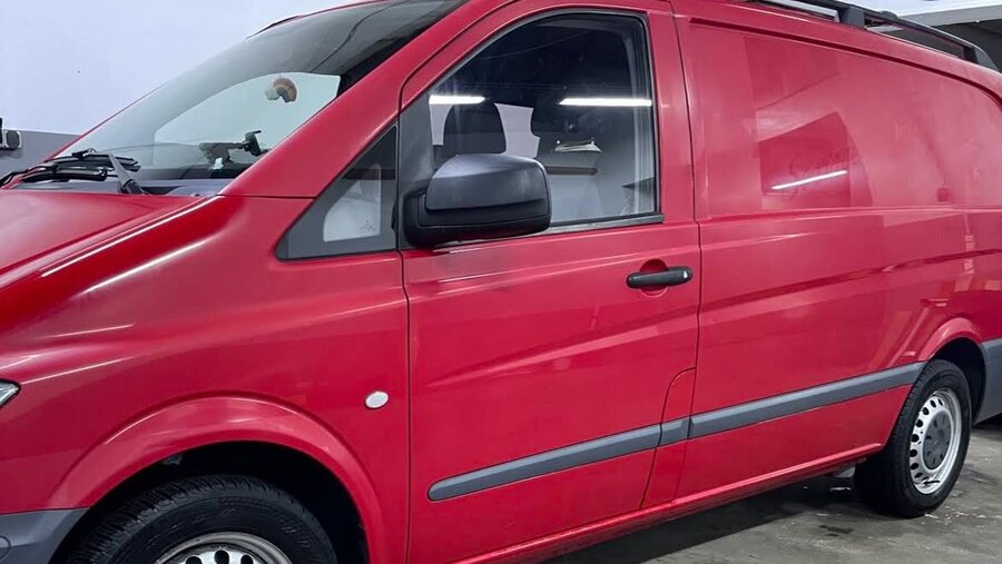 Verschmutzter roter Firmentransporter vor der Aussenreinigung
